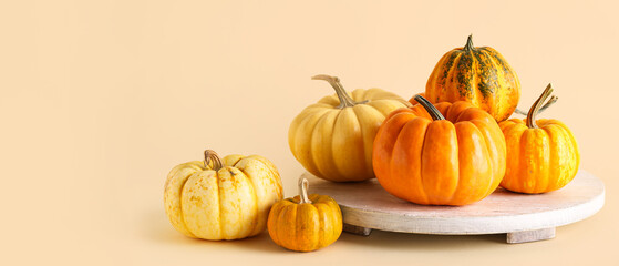 White board with fresh pumpkins on beige background
