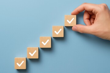 Building Blocks of Success: A hand carefully places a checkmark on the final wooden block, symbolizing completion and a steady progression.