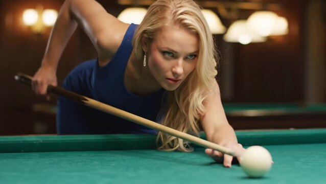 beautiful woman in blue is playing billiards