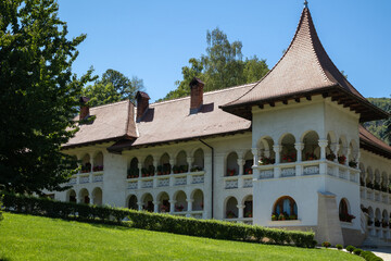 Obraz premium beautiful prislop monastery in romania, featuring a distinctive building with arched balconies, traditional roofs, and green gardens