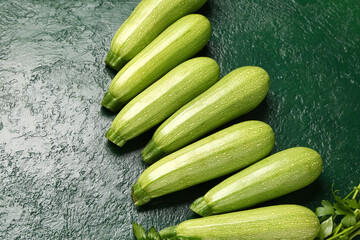 Many fresh zucchini and parsley on green background