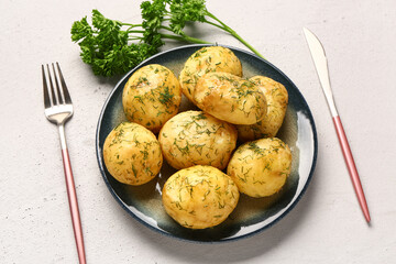 Plate of boiled baby potatoes with dill and parsley on white background