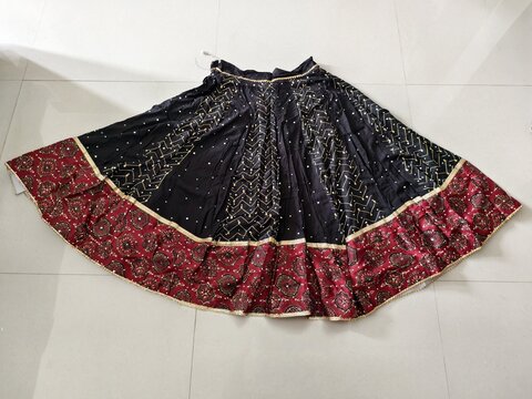 Traditional Navratri chaniya choli skirt with vibrant patterns displayed on floor, showcasing festive ethnic wear, cultural design and colorful Indian fashion.