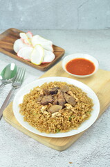 Delicious beef fried rice with egg, chilli, crackers and green onion, Indonesian dish.
