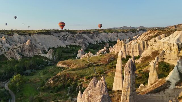 Hot air balloons float over Cappadocia's unique rock formations at sunrise