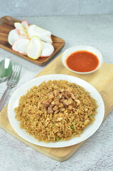 Delicious chicken fried rice with egg, chilli, crackers and green onion, Indonesian dish.