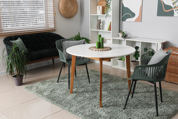 Beautiful living room with table, black cozy sofa and shelving unit
