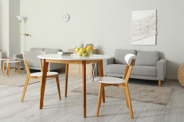 Interior of light room with dining table and sofas