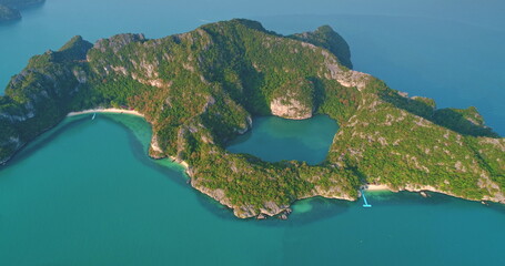 Fototapeta premium Breathtaking aerial view revealing Mae Ko island in Ang Thong National Marine Park, Thailand, featuring lush vegetation, a hidden lagoon, and vibrant turquoise waters