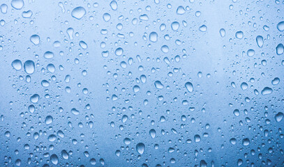 A close-up view of water droplets on a surface, creating a serene blue background with a calming effect.