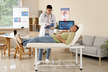 Young urologist working with mature man on couch in clinic