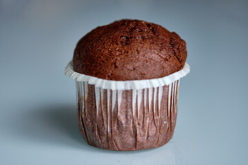 Freshly baked chocolate muffin displayed on a smooth surface after cooling at a bakery or home kitchen