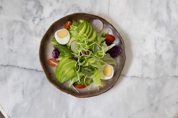 Fresh salad with avocado and tomatoes on a plate