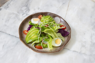 Fresh salad with avocado and tomatoes on a plate