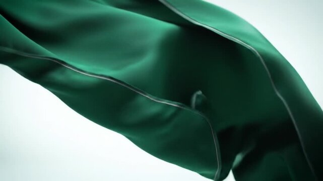 Graceful green fabric waving against a clean background, a symbol of pride and celebration. Close-up of elegant silken textile flowing.