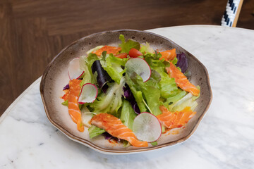 Fresh salad with shrimps and salmon served with vegetables on a plate