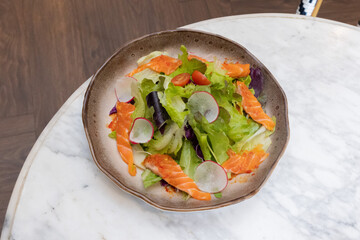 Fresh salad with shrimps and salmon served with vegetables on a plate