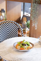 Fresh salad with shrimps and salmon served with vegetables on a plate