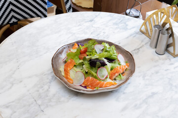 Fresh salad with shrimps and salmon served with vegetables on a plate