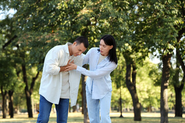 Fototapeta premium Young woman and her husband having heart attack on street
