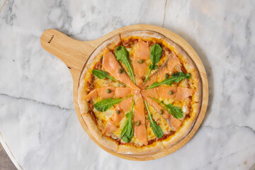 Baked pizza with smoke salmon and melted cheese casserole