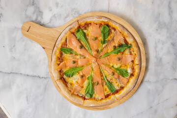 Baked pizza with smoke salmon and melted cheese casserole