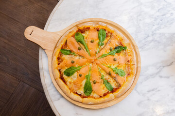 Baked pizza with smoke salmon and melted cheese casserole