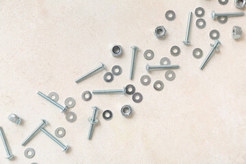 Tap bolts and chrome nuts on white grunge background