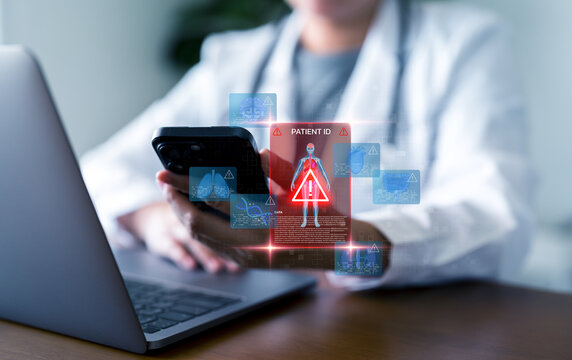 Medical data security, anatomy organ, healthcare cybersecurity, and digital patient information protection concepts. Doctor using smartphone and laptop with holographic patient ID warning. - Powered by Adobe