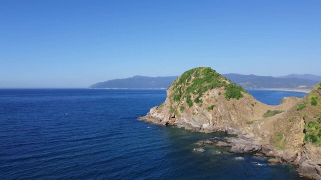 Aerial view of a summer vacation beach crowded with people swimming and having fun enjoying the holiday, a sandy beach full of umbrellas on a hot day and an island in Mediterranean sea, jijel Algeria