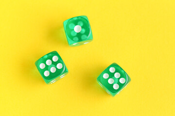 Green game dices on yellow background