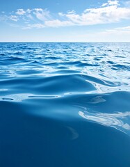 Calm ocean surface, blue water, slight waves, clear sky