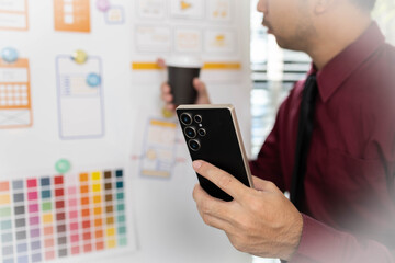 A man is working on a mobile user interface design project. He is focused on the task at hand and appears to be in a creative mood.


