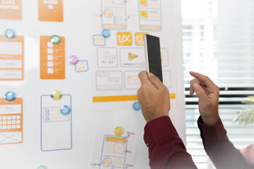 A man is working on a mobile user interface design project. He is focused on the task at hand and appears to be in a creative mood.

