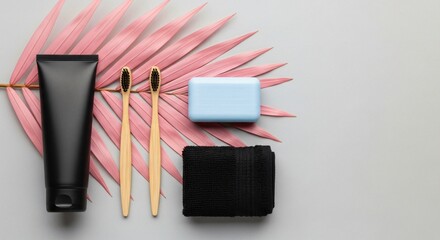 Natural bamboo toothbrushes, black paste tube, soap, towel, pink leaf