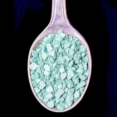 closeup of dried spirulina powder in a spoon with vivid green color macro algaebased superfood photography clean background