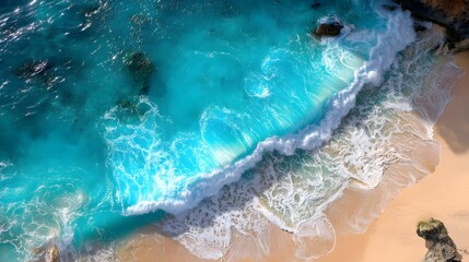 Turquoise waves crashing on a sandy beach.