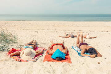 Group of People Sunbathing on Sandy Beach