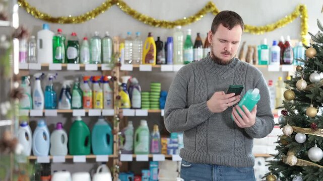 Checking expiration date of shower gel or champoo - male shopper scans QR code on label of shower gel or champoo using her smartphone. High quality 4k footage