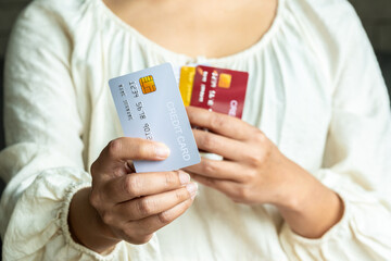 Woman holding several credit cards and he is choosing a credit card to pay and spend Payment for goods via credit card. Finance and banking concept	
