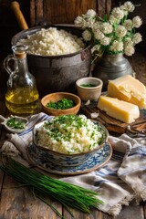 Creamy risotto, garnished with fresh chives, sits in a bowl, surrounded by ingredients.  A large pot of risotto, olive oil, parmesan cheese, and  white clover sprigs are displayed