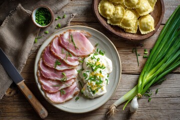Sliced cured meat and creamy sauce, garnished with fresh chives, served alongside pasta pockets on a light gray plate.  Wooden table background