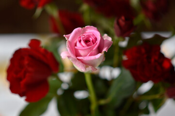 bouquet of colorful roses in the clay vintage vase at the table