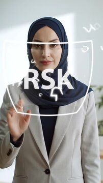 Professional woman in a hijab interacts with a futuristic transparent screen, symbolizing digital innovation and advanced data technology in a modern business setting.