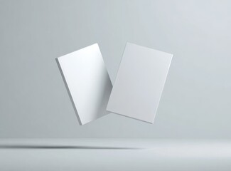 Two blank white books levitate, angled slightly apart, against a plain, light gray background