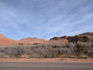 Desert landscape with red rocky mountains and a clear blue sky in a remote area in Morocco