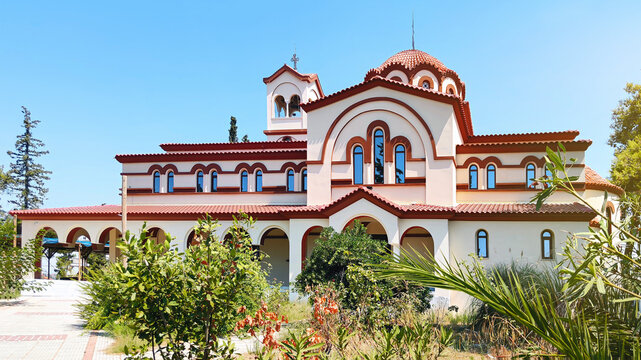 Monastery of Saint Arsenios the Cappadocian in Ormylia, a beautiful Byzantine-style Orthodox church and pilgrimage destination in Halkidiki, Greece, surrounded by lush gardens under a clear summer sky