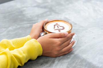Close-up image of a cup of coffee held in hands.Hand-roasted coffee, authentic coffee. A dose of caffeine.