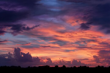 Cumulus clouds radiating warm shades of orange and purple against a serene sunset horizon in tranquil nature scene