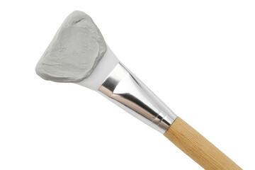 Cosmetic brush applying clay mask on transparent background